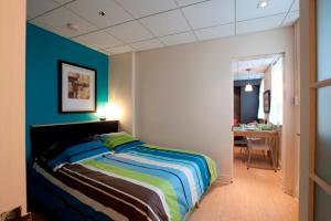 a bedroom with a bed and a blue wall at ZUM MTL Auberge d'été - Université de Montréal in Montréal