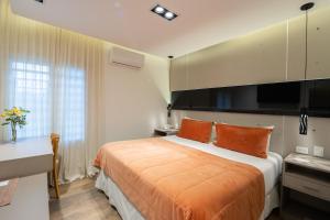 岑特纳里奥全球酒店 的卧室里有一张床，上面铺着橙色的毯子