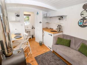 a living room with a couch and a kitchen at King's Cwtch Shepherd's Hut in Cardiff