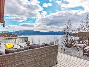 a couch on a deck with a view of a lake at 4 star holiday home in Valevåg in Valevåg +28 photos
