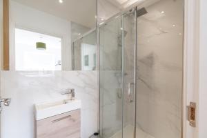 a bathroom with a glass shower and a sink at Sleek & Cozy 2BR Apartment for Your Stay # 3 in Rothley