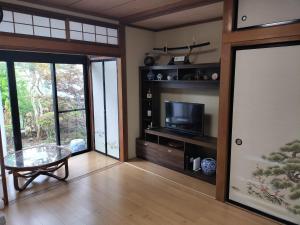 a living room with a tv and a glass table at 世界文化遗产三保松原 徒步3分钟 和服体验 160平独栋日式民居 民宿 松原 in Shizuoka