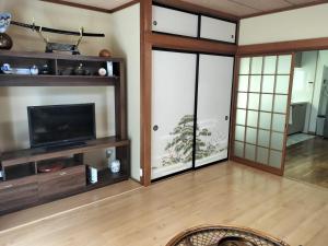 a living room with a tv and sliding glass doors at 世界文化遗产三保松原 徒步3分钟 和服体验 160平独栋日式民居 民宿 松原 in Shizuoka