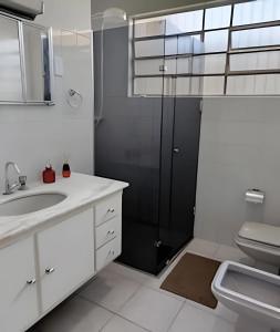a bathroom with a shower and a sink and a toilet at Unidade 2 in Bauru +25 photos