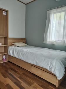 a bedroom with a large bed with a window at 民泊松原 in Shizuoka