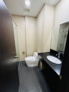 a bathroom with a toilet and a sink at Town Apartment next to The Spring Bintulu in Bintulu