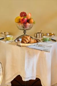 einen Tisch mit einer Schale Obst und einer Schüssel Brot in der Unterkunft Ca Fosca in Bologna