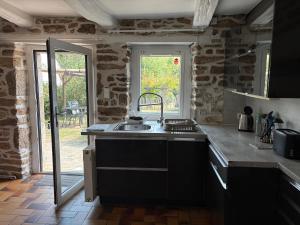 eine Küche mit Spüle und Arbeitsplatte in der Unterkunft Gîtes du phénix in Pont-Aven + 2 Fotos