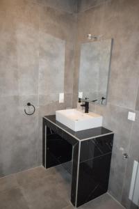 a bathroom with a sink and a mirror at Casa Elia AXD in Alexandroupoli +10 photos