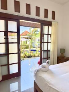 a bedroom with a bed and a view of a pool at Bali Stuti Jimbaran Inn in Jimbaran