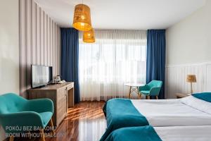 une chambre d'hôtel avec un lit et une télévision dans l'établissement Ach Mazury, à Mikołajki