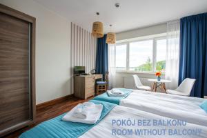 une chambre avec un lit et une pièce avec une fenêtre dans l'établissement Ach Mazury, à Mikołajki