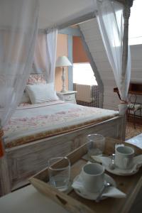 a bedroom with a bed with a tray with cups and glasses at La Grange des Marettes in Cléres