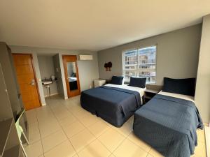 una camera d'albergo con due letti e una finestra di Melhor vista de João Pessoa 301 a João Pessoa