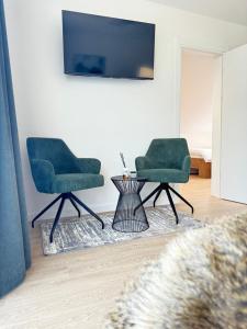 two green chairs and a table in a living room at Cara Grand Chalet in Braşov