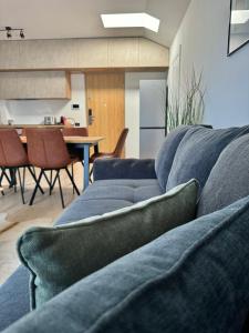 a living room with a blue couch and a kitchen at Cara Grand Chalet in Braşov