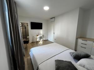 a bedroom with a bed and a table and a television at Landing Rooms in Močići