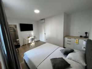 a bedroom with a bed and a desk and a television at Landing Rooms in Močići