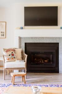 a living room with a fireplace with a television above it at Lodge Condo 35 in Stowe