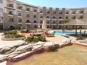 a resort with a swimming pool and a large building at Royal Beach Resort in Hurghada