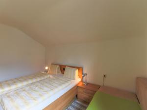a small bedroom with a bed and a night stand at Cottage in Piesendorf near Zell am See Ski Area in Piesendorf +16 photos