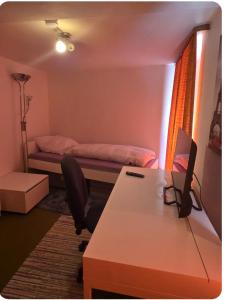 una habitación con una cama y un escritorio con una computadora en Ferienzimmer in bad friedrichshall, en Bad Friedrichshall