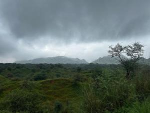 a view of a field with mountains in the background at R-Pragya Farmstay in Amarsar +8 photos