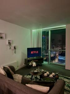 Una sala de estar con un sofá y un televisor. en Luxurious Rotunda City View Apartment in Birmingham City Centre, en Birmingham