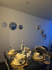 una mesa de comedor con platos y copas de vino en Luxurious Rotunda City View Apartment in Birmingham City Centre, en Birmingham