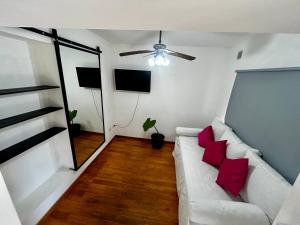 a living room with a white couch with red pillows at La Ribera in Concepción del Uruguay