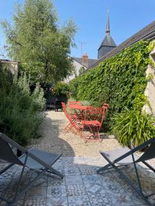 a red table and chairs in a garden at La Venise de Sologne in Romorantin
