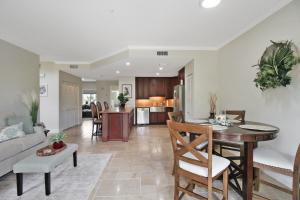 a living room and kitchen with a table and chairs at Shell Yeah 3 Story Condo On AMI in Holmes Beach