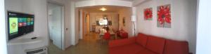 ジャルディーニ・ナクソスにあるBaia Giardini Apartmentsのリビングルーム(赤いソファ、テレビ付)