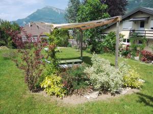 a garden with a pergola and some flowers at Zimmer mit Frühstück in Challes-les-Eaux