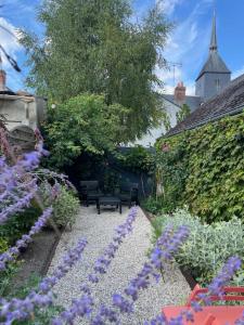 a garden with purple flowers and a bench at La Venise de Sologne in Romorantin