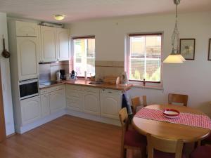 a kitchen with white cabinets and a table and a dining room at Apartment in St Michael near Ski Slopes in Sankt Martin