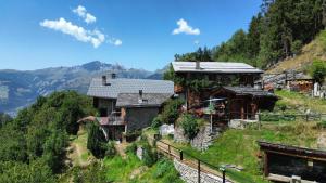 ein Haus auf einem Hügel mit Bergen im Hintergrund in der Unterkunft Chalet Roger in Montvalezan