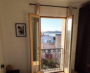a door to a balcony with a view of the ocean at Soul Apartment La Maddalena in La Maddalena +47 photos
