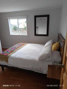 a bedroom with a large bed with a window at Pflaumen dormitorios in Valdivia