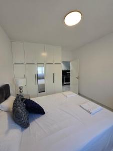 a bedroom with a large white bed with a lamp at Pafos modern gem apartment margarita gardens block 6 in Paphos City
