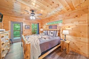 a log cabin bedroom with a bed and a ceiling fan at Poolin Around by American Patriot Getaways in Glade +47 photos