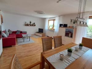 a living room with a table and a red couch at Im Idyll 3 in Hengersberg