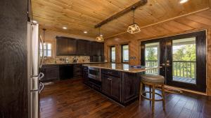 a kitchen with wooden floors and a wooden ceiling at Peak of Perfection by American Patriot Getaways in Rocky Grove