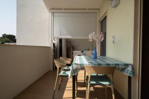 a dining room with a table with chairs and a vase of flowers at Deliziosa Home in Torre a Mare