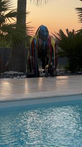 a statue of an elephant on a skateboard next to a pool at Luxury home private duras in Duras +36 photos