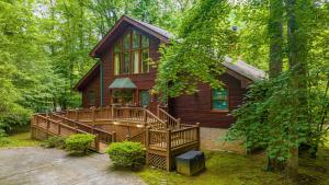 Cabaña de madera en el bosque con porche en Rivers Edge by American Patriot Getaways, en Pittman Center