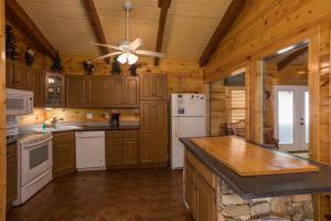 a kitchen with wooden cabinets and a ceiling fan at Rustic Ranch by American Patriot Getaways in Waldens Creek