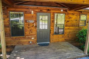 a wooden cabin with a door and windows at Seclusion by American Patriot Getaways in McCookville