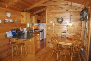 a kitchen with a table and chairs in a cabin at Seclusion by American Patriot Getaways in McCookville