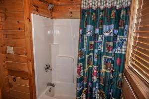 a bathroom with a shower with a shower curtain at Seclusion by American Patriot Getaways in McCookville +17 photos